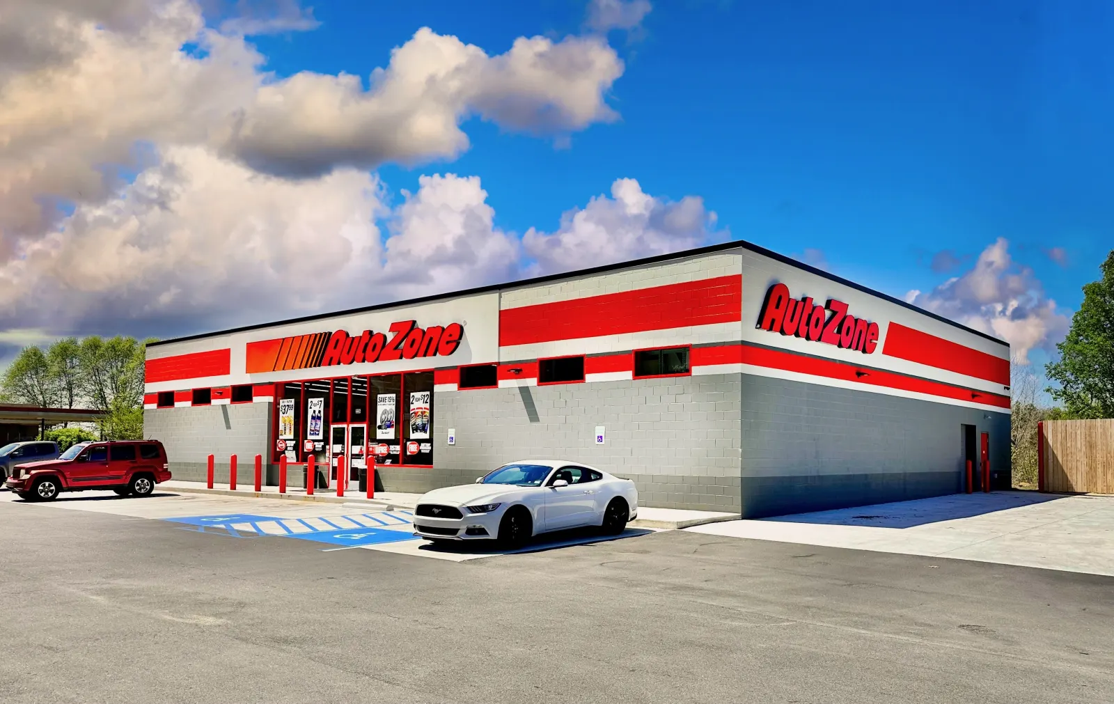 A modern AutoZone store exterior under a blue sky